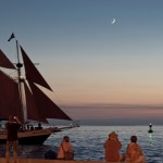 Sunset Celebration revelers watching the sun go down and a schooner sail by. Photo by Capt. Steven Lamp.