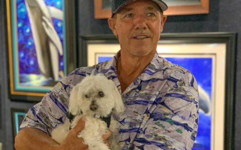 Wyland holding Puppy in Key West art Gallery